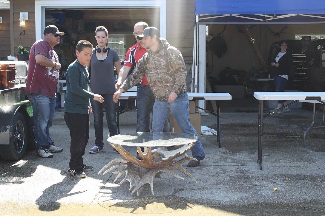 A group of people standing around a crab shaped table