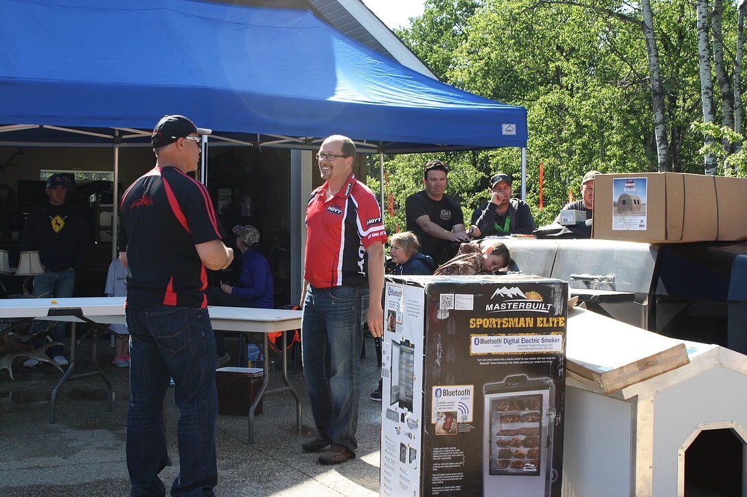 A group of men standing in front of a blue tent