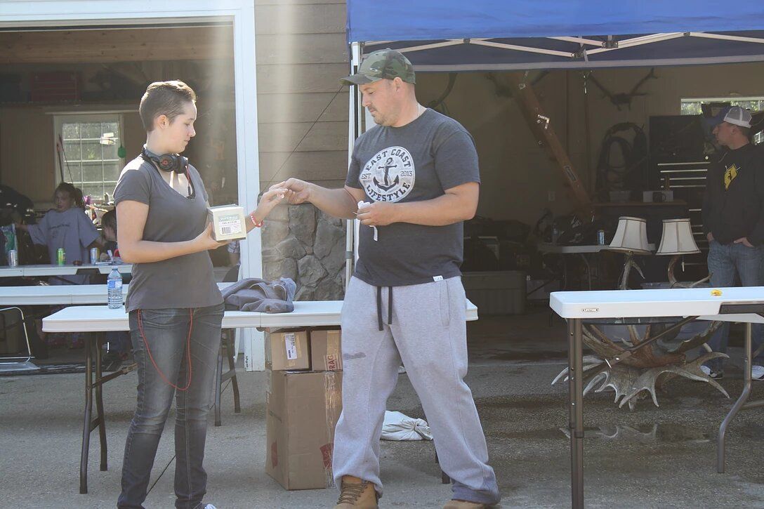 A man and a woman are standing under a blue tent