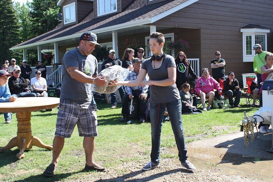 A man and a woman are standing in front of a group of people.
