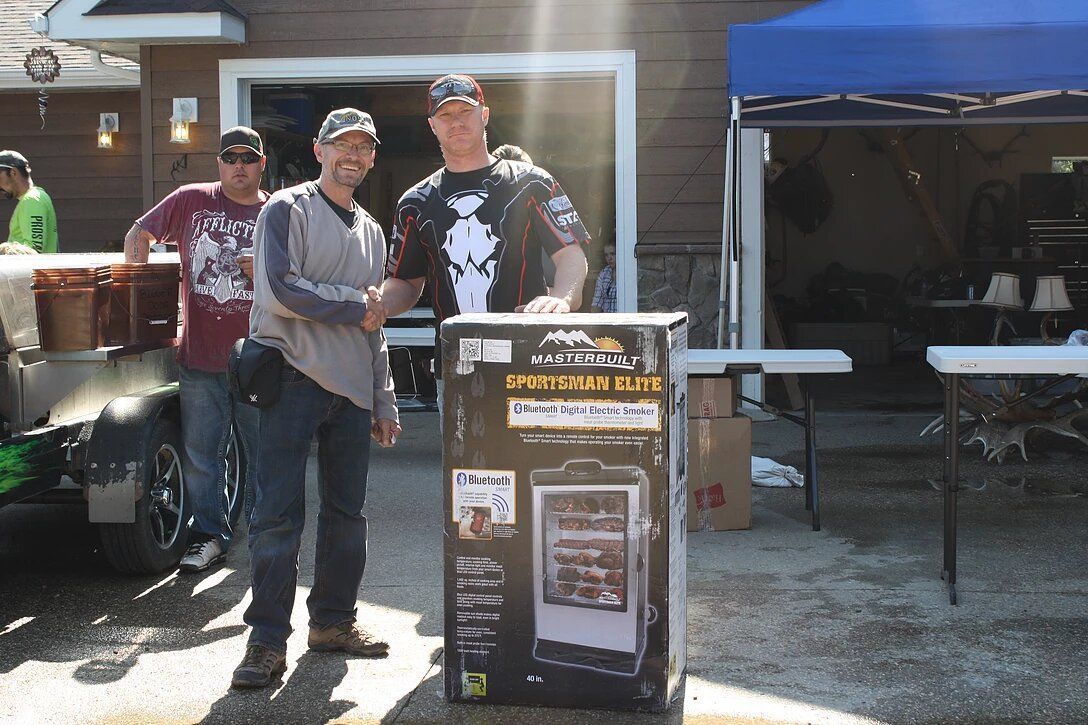 A man is shaking hands with another man while standing next to a box.