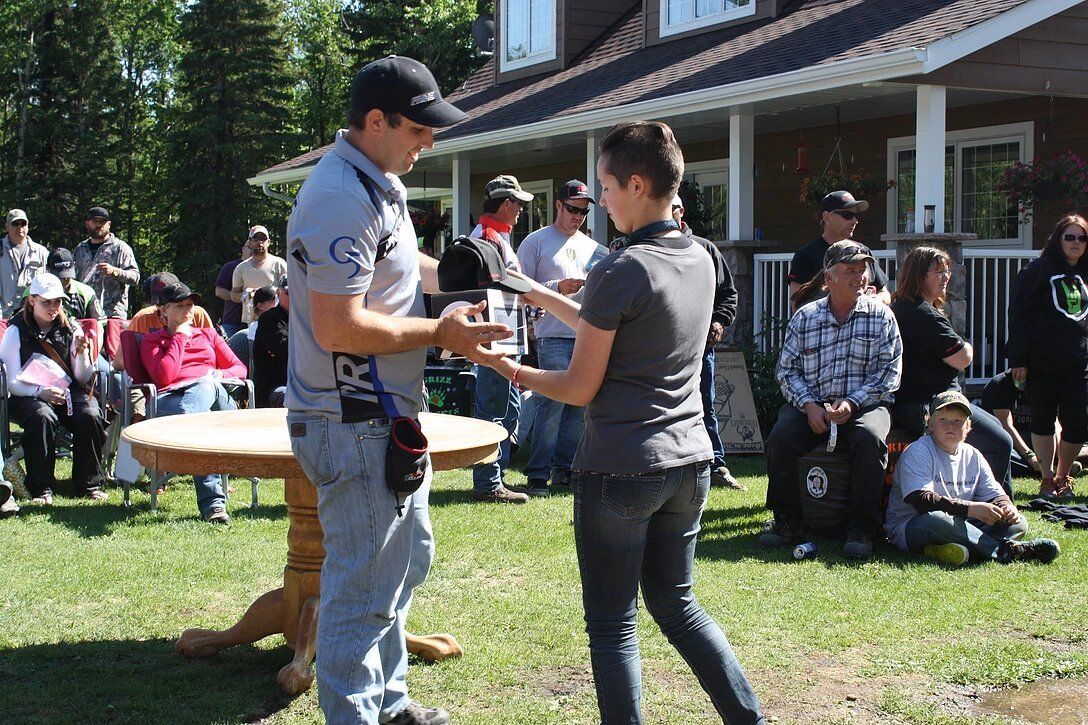 A man is giving a woman a trophy in front of a crowd of people.