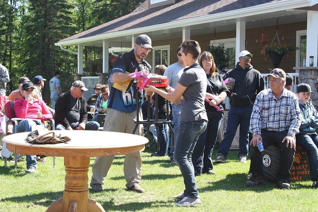 A group of people are standing around a table in front of a house.
