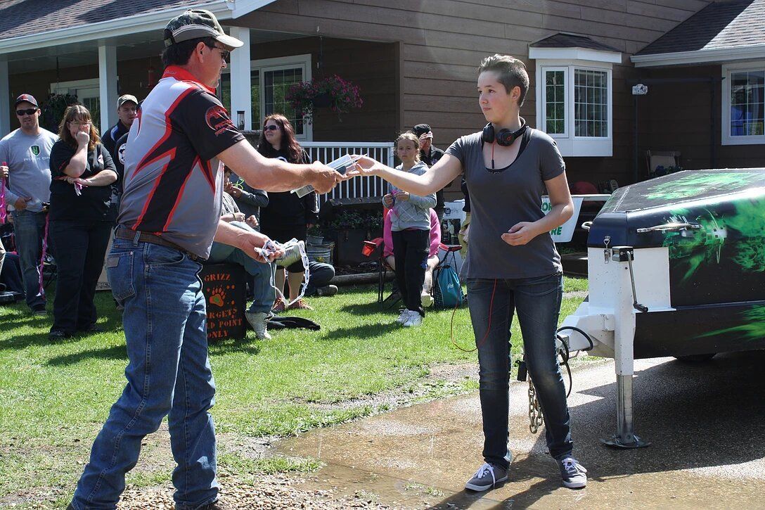 A man and a woman are shaking hands in front of a house