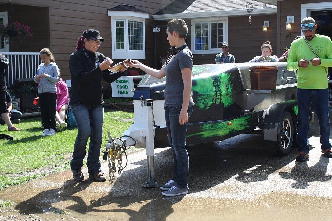 A group of people are standing in front of a trailer.