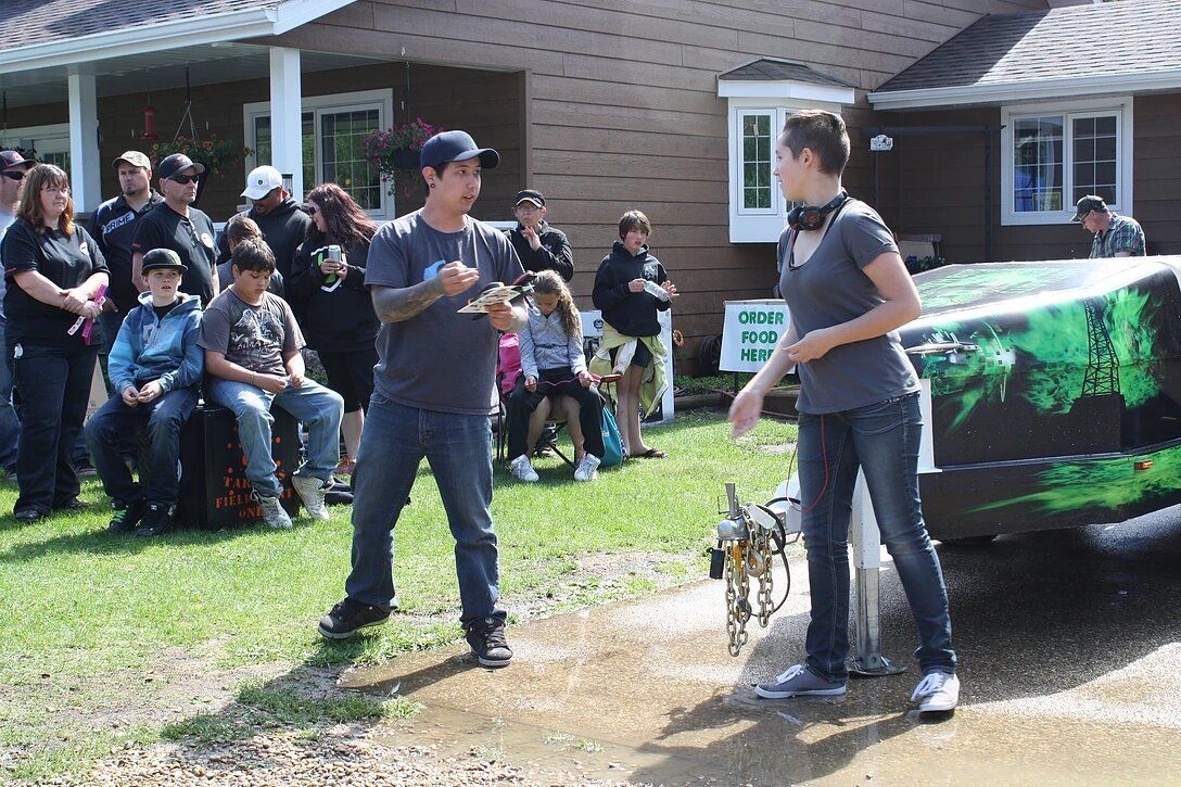 A man and a woman are standing in front of a house talking to each other
