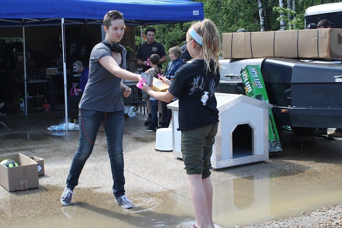 A man and a girl are standing in a puddle of water.