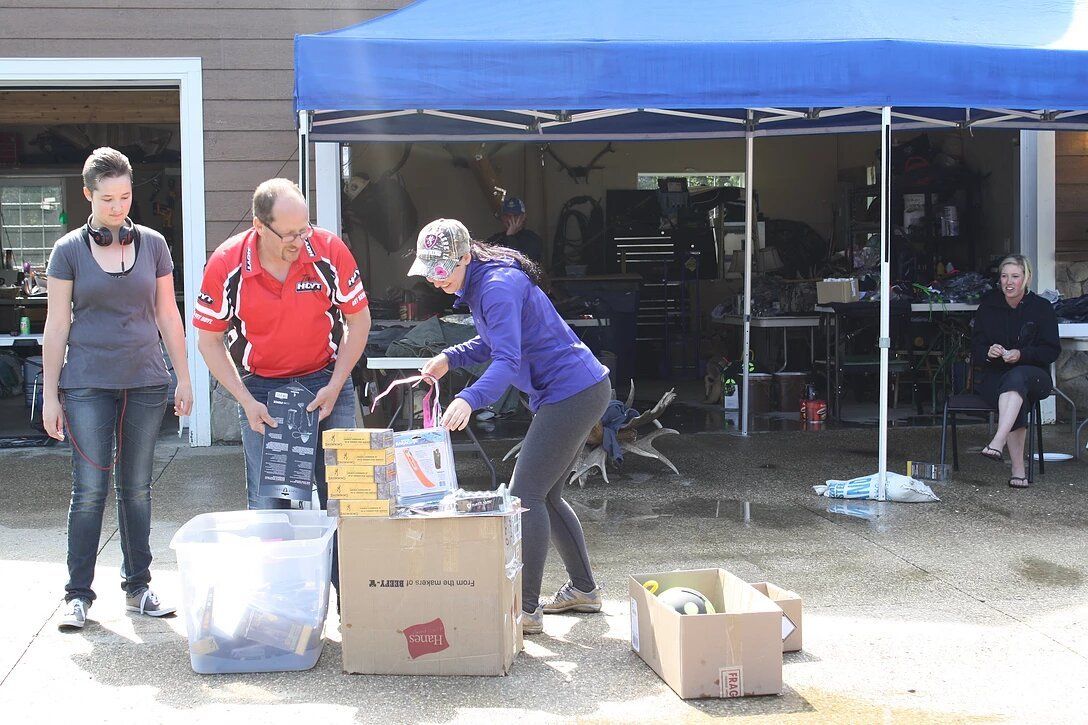 A group of people are standing in front of a blue tent.