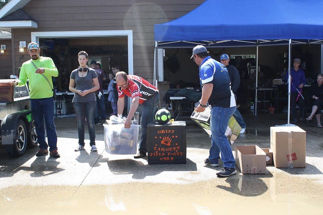 A group of people are standing in front of a garage.