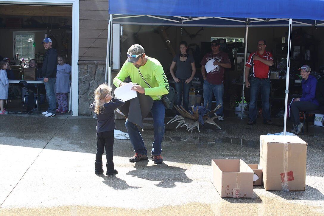 A man is giving a little girl a piece of paper