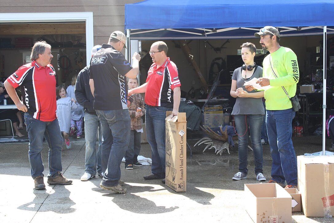 A group of people are standing in front of a garage talking to each other