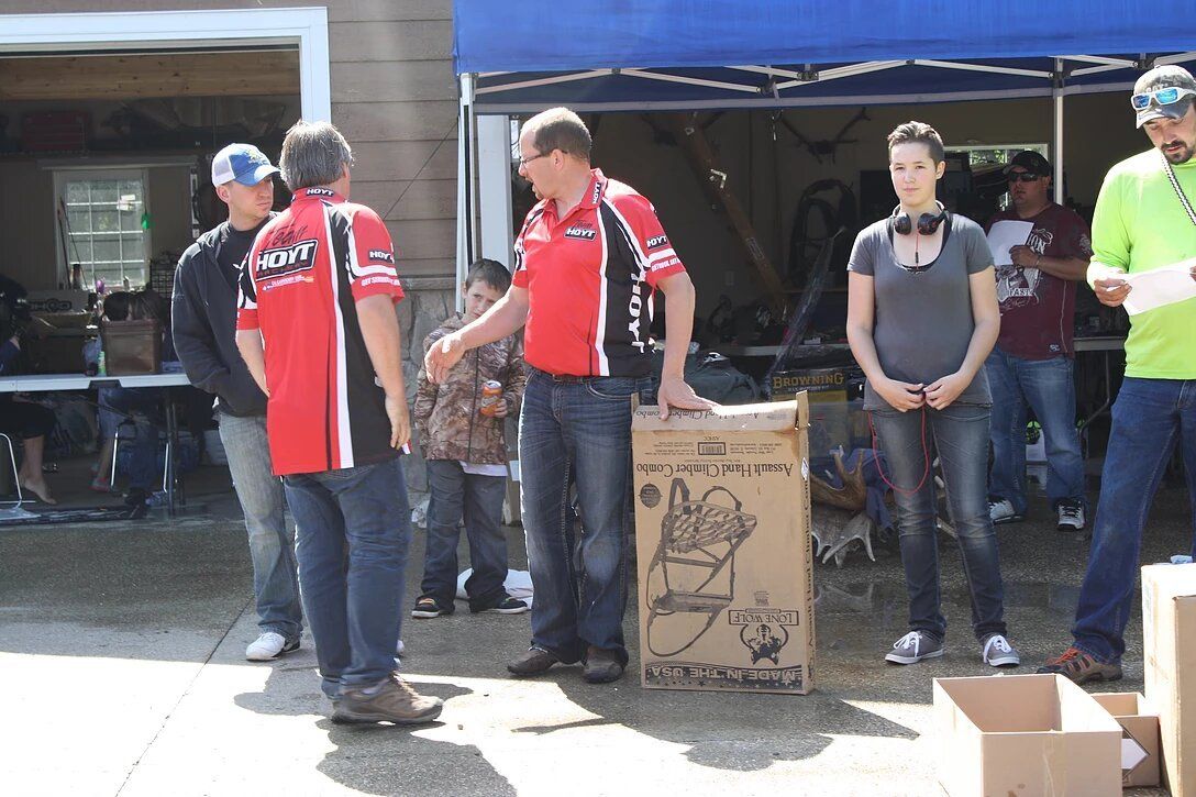 A group of people standing around a cardboard box that says ' a ' on it