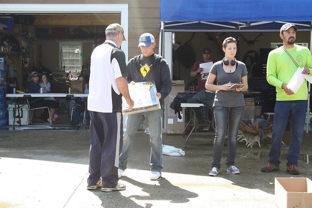A group of people standing in front of a blue tent
