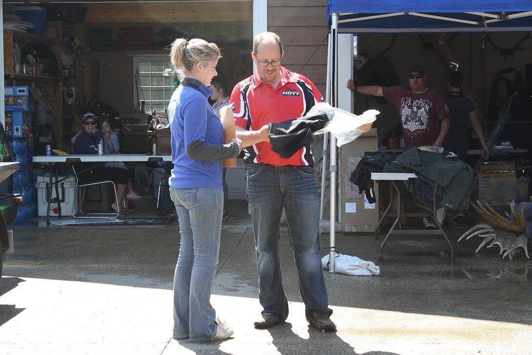 A man in a red shirt is talking to a woman in a blue shirt