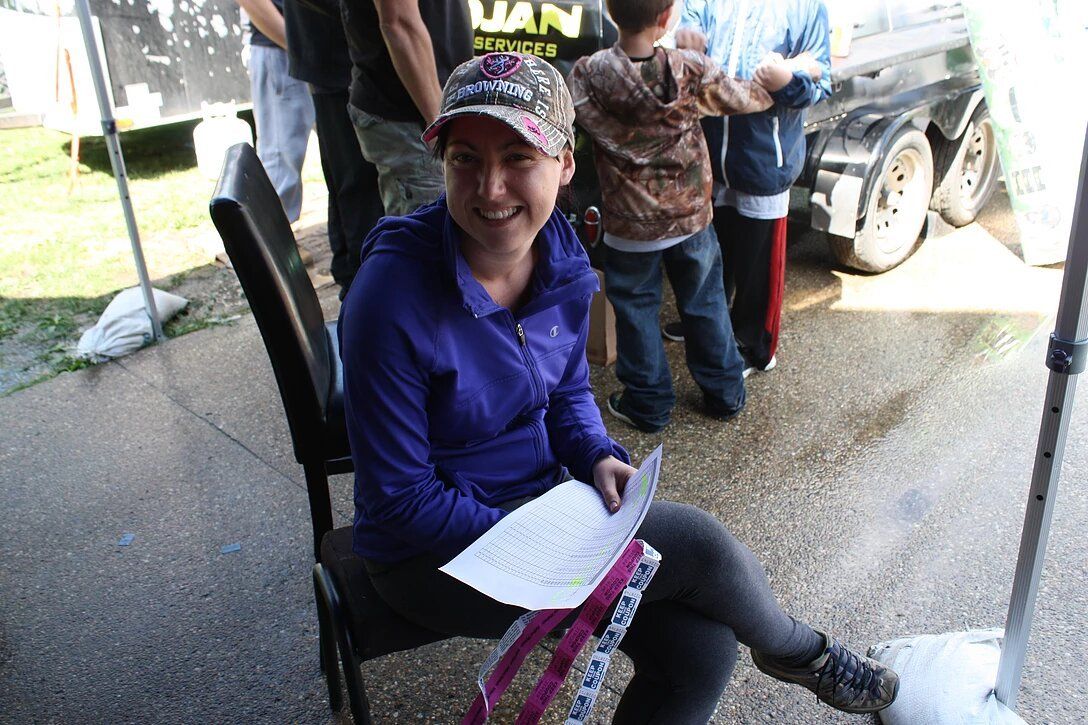 A woman in a purple shirt is sitting in a chair holding a piece of paper