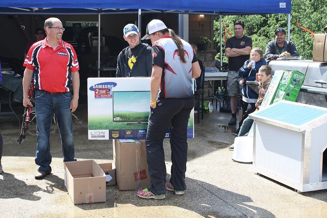 A group of people are standing in front of a blue tent.