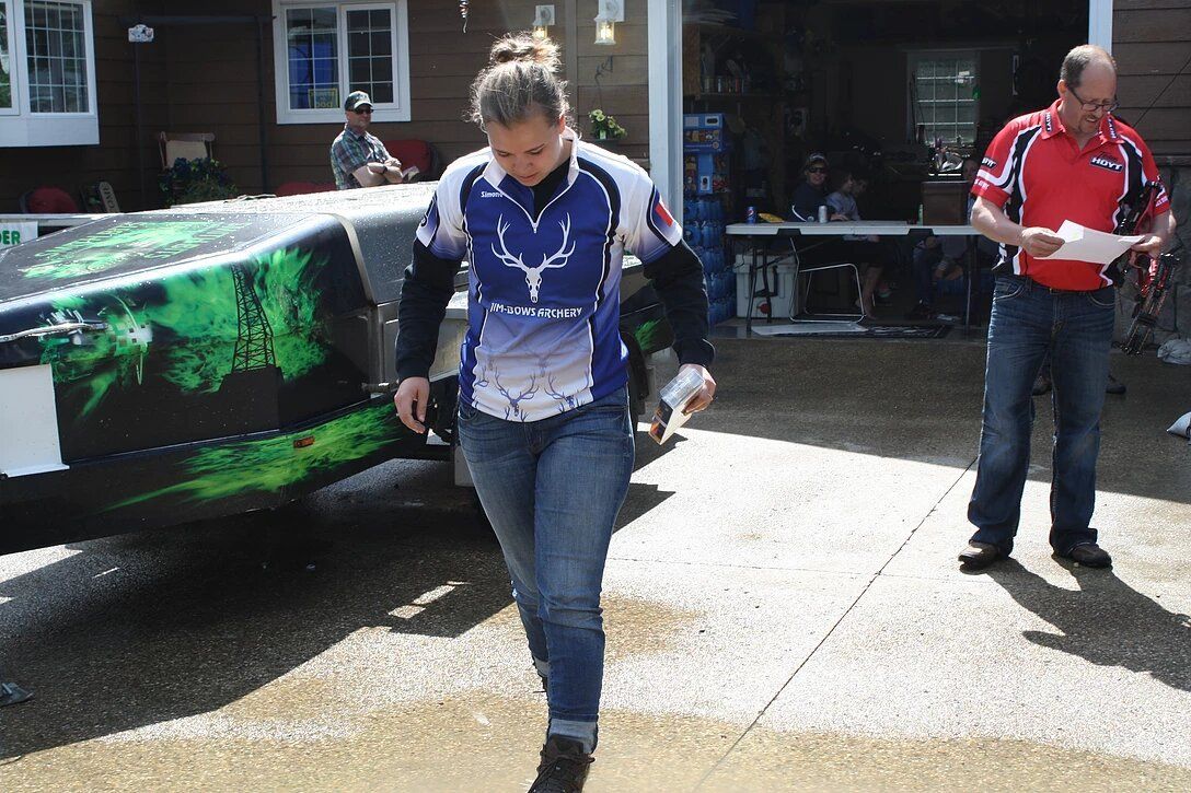 A woman in a blue shirt is walking towards a boat