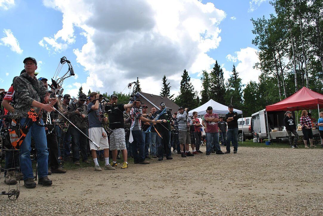 A group of people are standing in a dirt field.