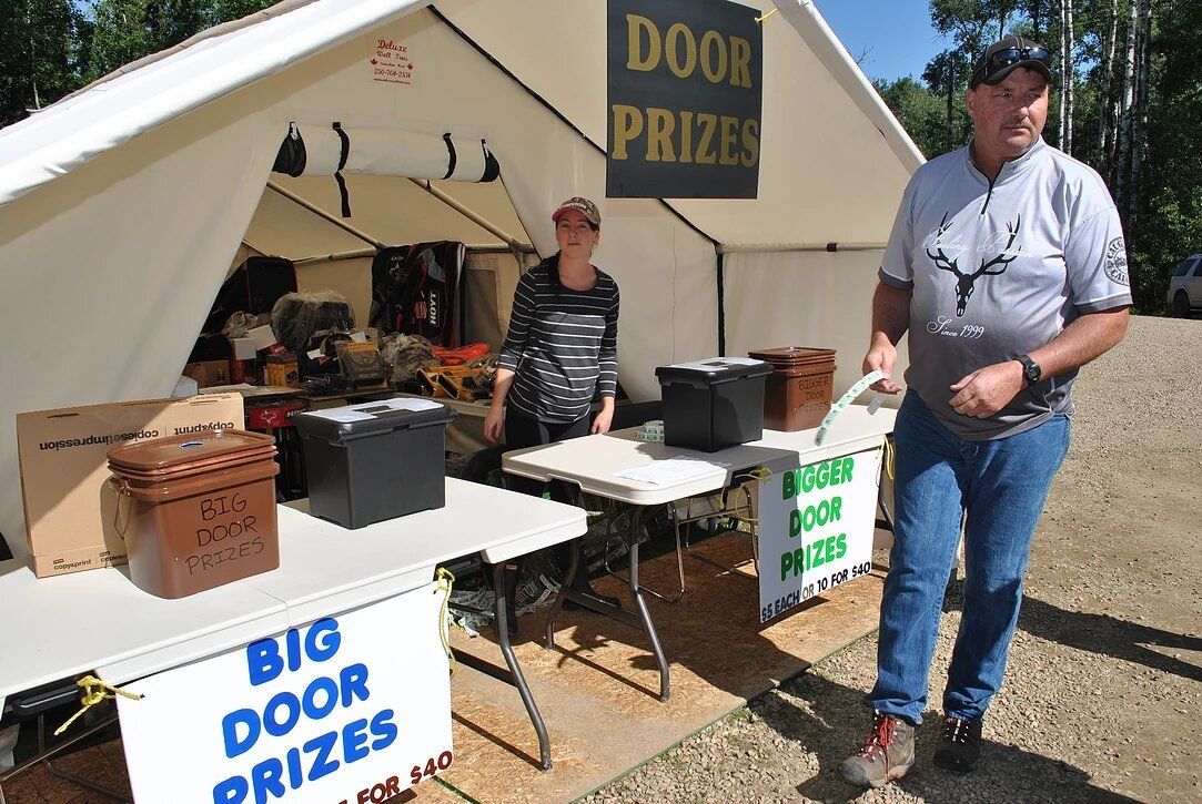 A man standing next to a table that says big door prizes