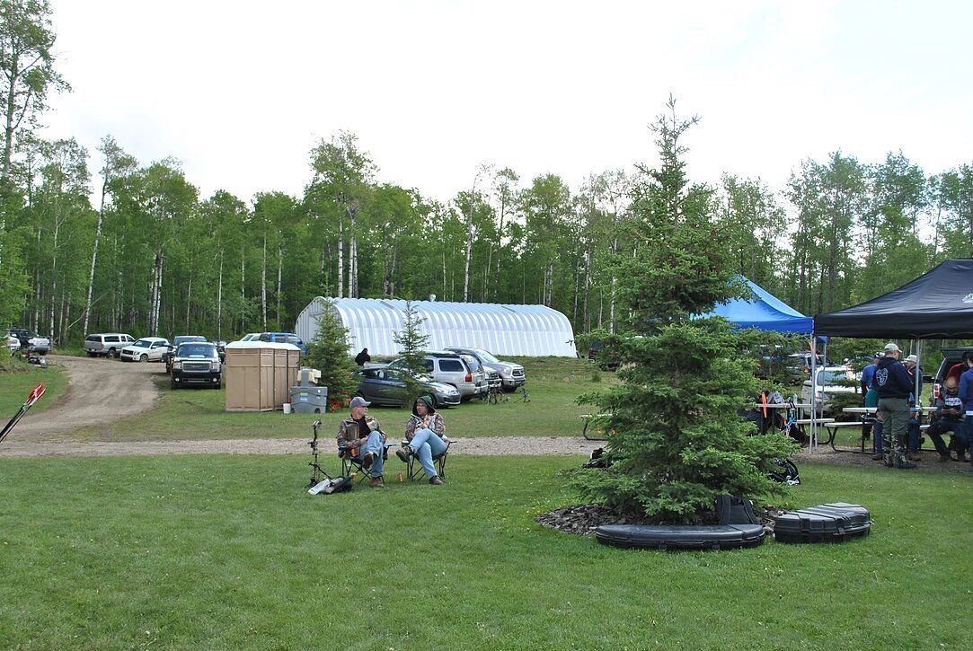 A group of people are sitting in chairs in a grassy field.