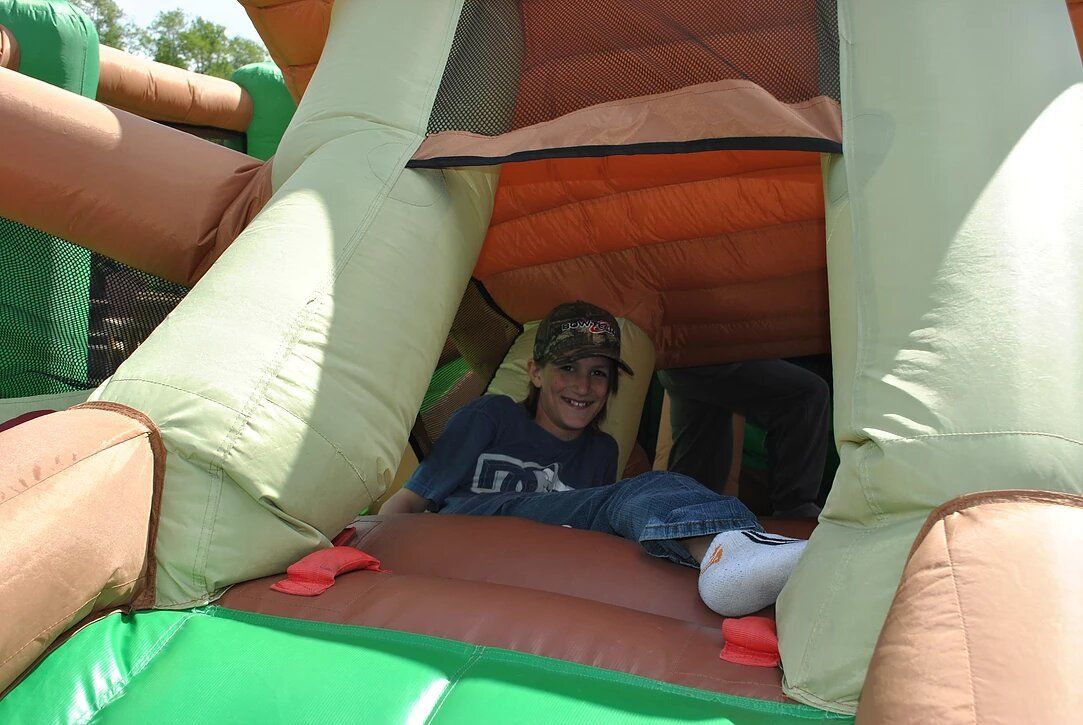 A young boy is playing in a bouncy house.
