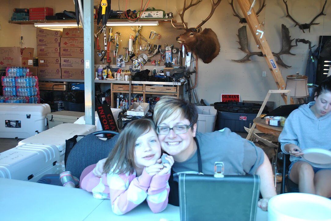 A man and a girl are posing for a picture in a garage