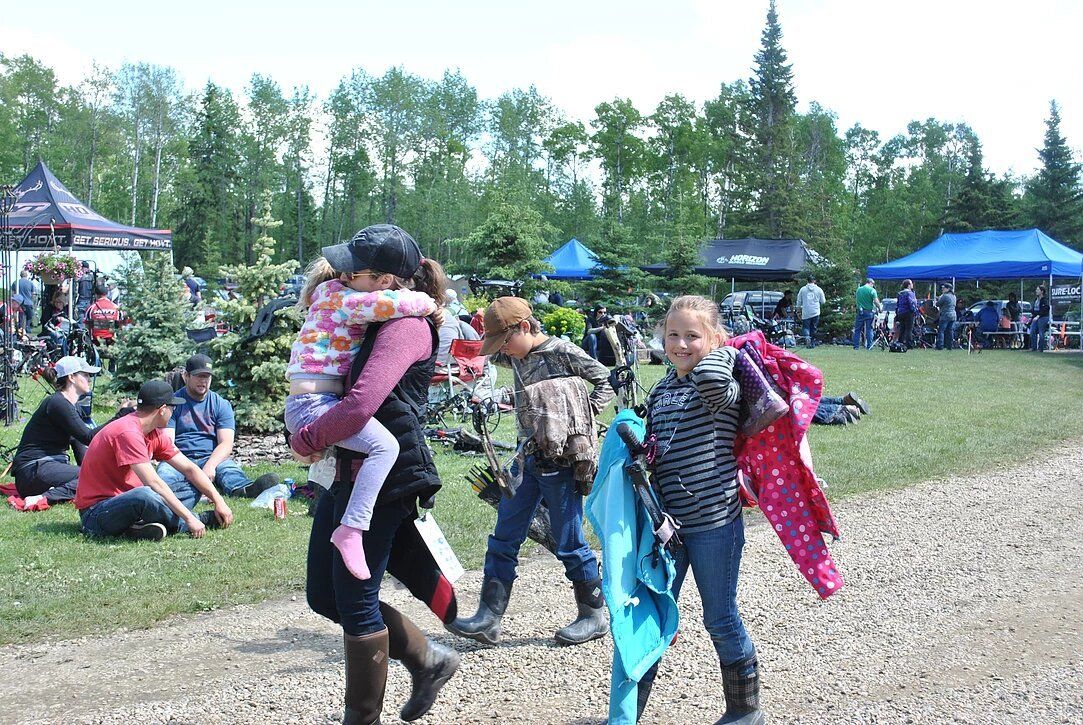 A woman is carrying a child on her back in a field.