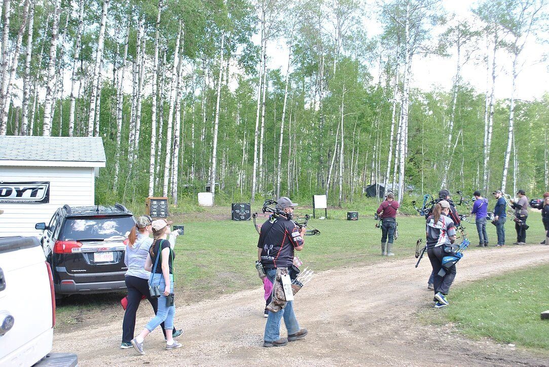 A group of people are walking down a dirt road.