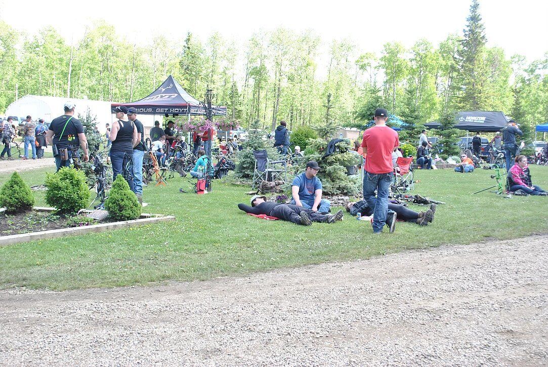 A group of people are sitting on the grass in a park.