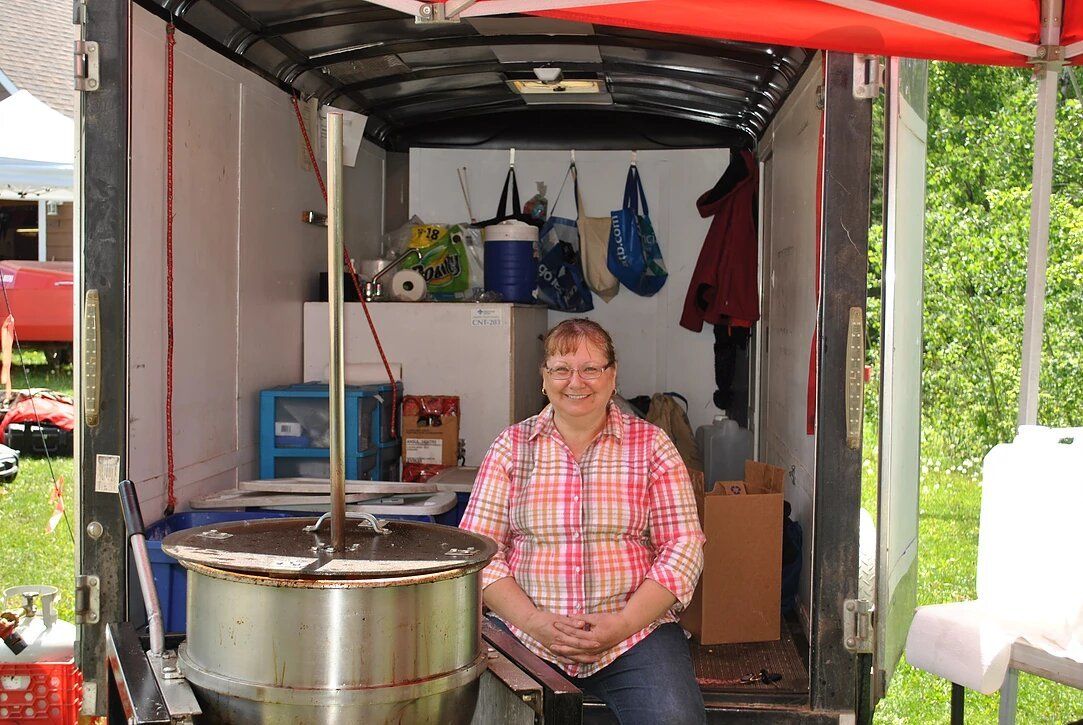 A woman is sitting in the back of a truck.