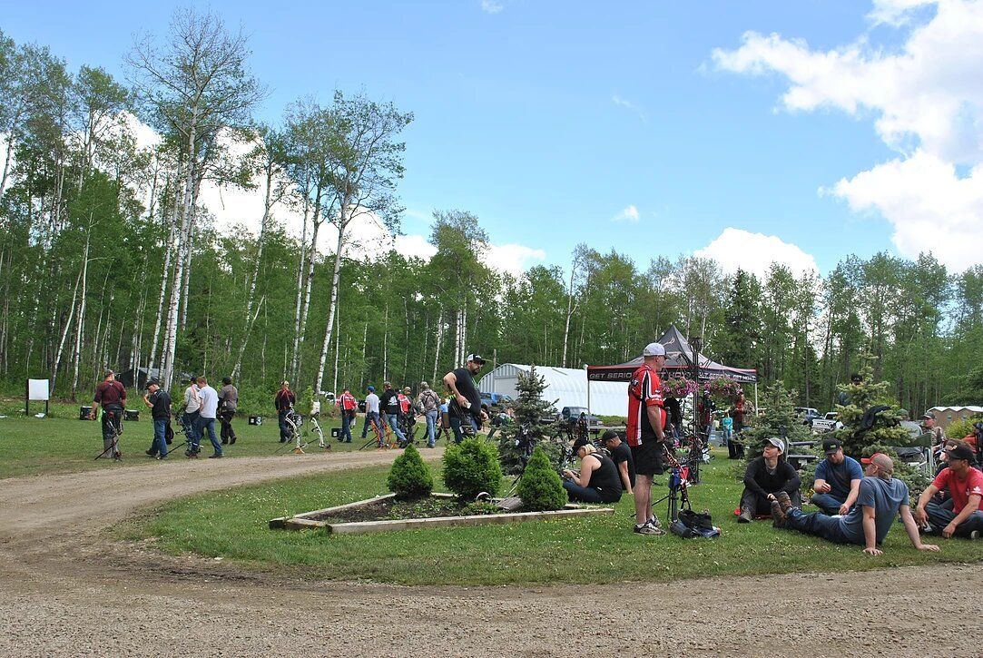 A group of people are sitting on the grass in a field