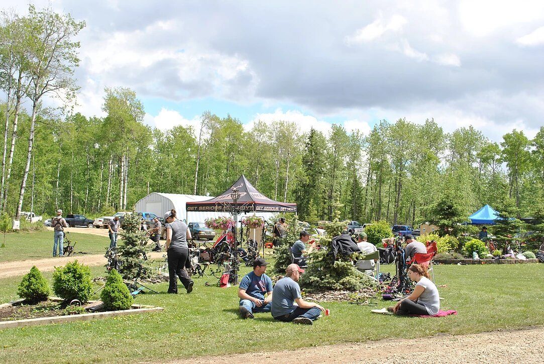 A group of people are sitting on the grass in a park.