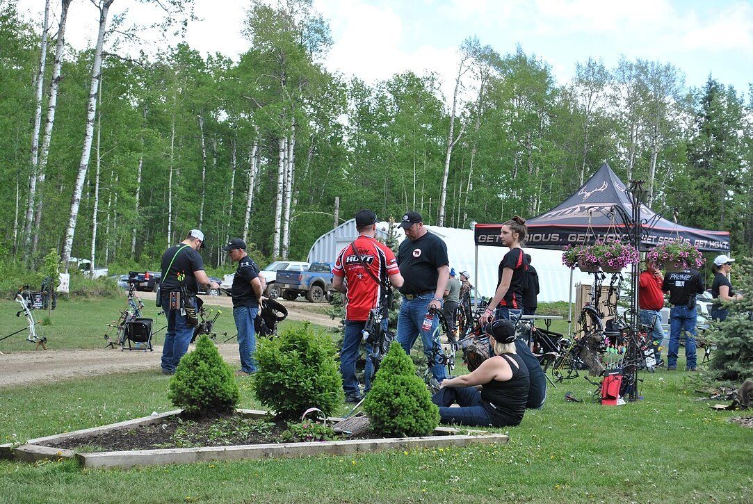 A group of people are standing in a grassy field.