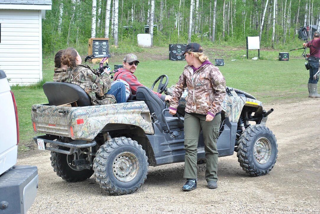 A group of people are sitting in an atv talking to each other.