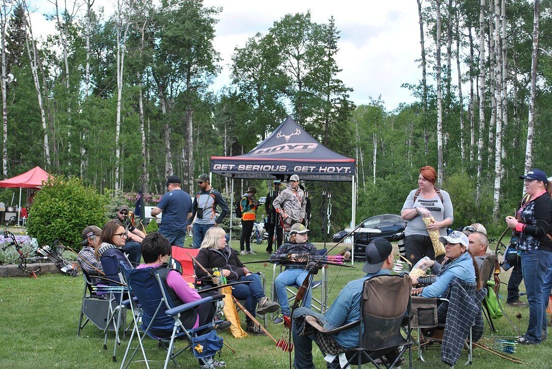 A group of people are sitting in chairs in a field.