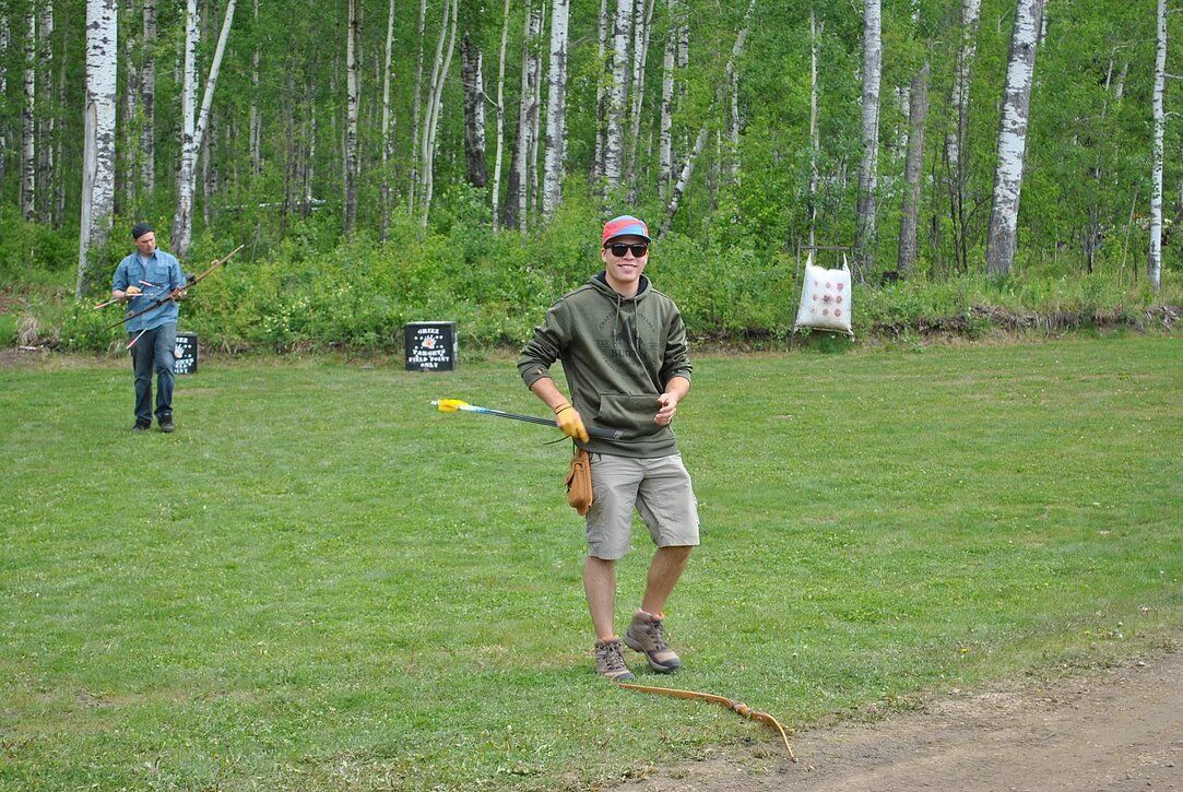 A man is standing in a field holding a frisbee.