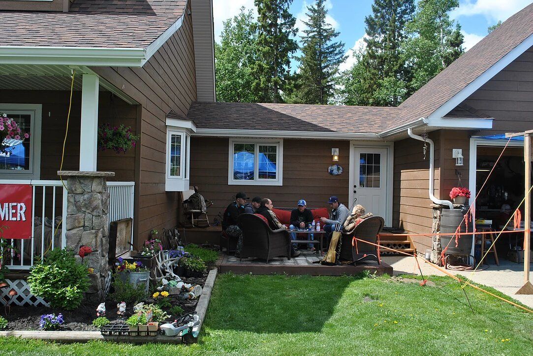 A group of people are sitting on the porch of a house.