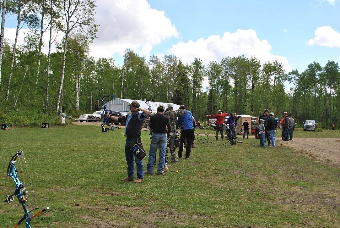 A group of people standing in a field with trees in the background