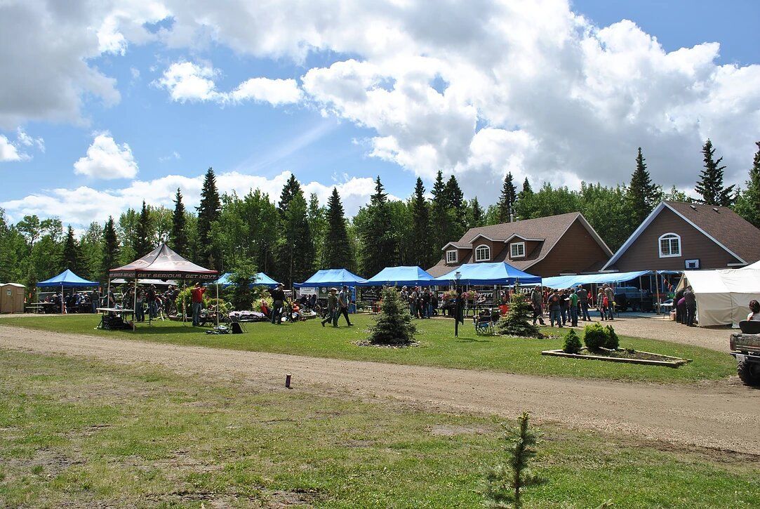 A group of people are gathered in a field in front of a house.