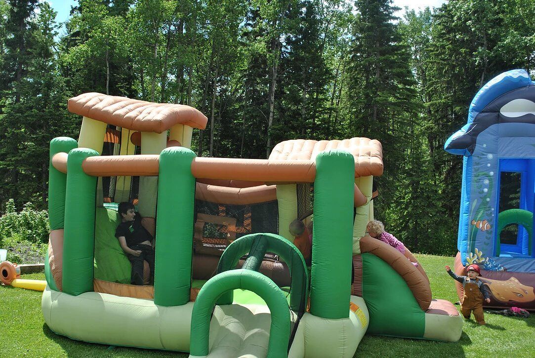 A group of inflatable toys are sitting on top of a lush green field.