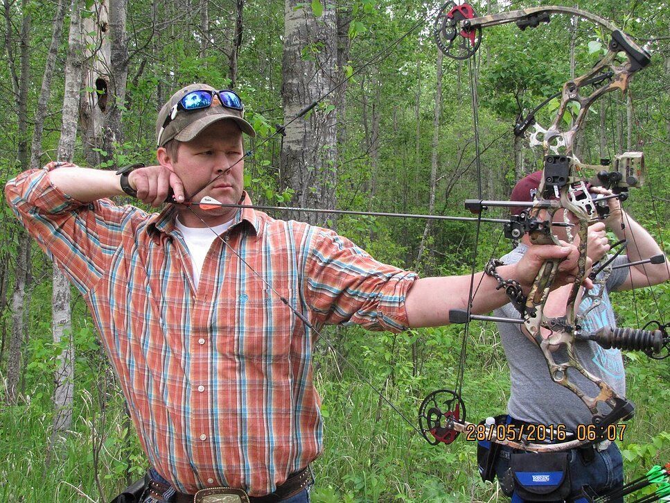 Archery shooting an arrow at a field target.
