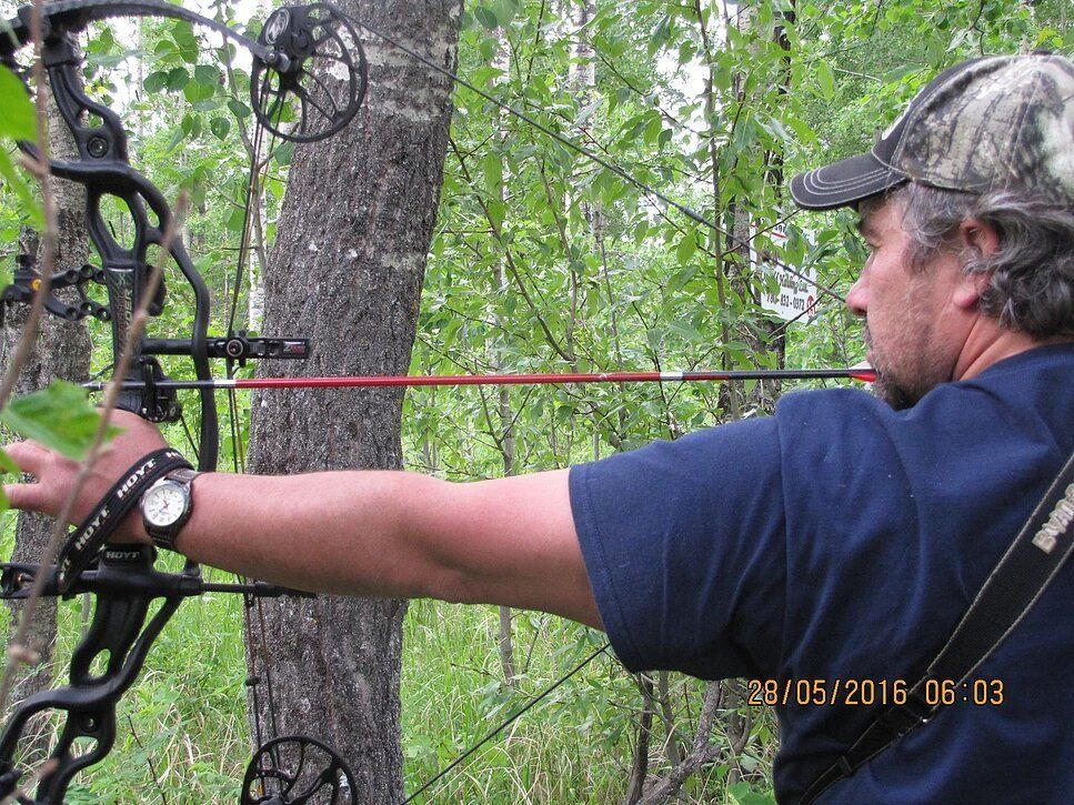Archery shooting an arrow at a field target..