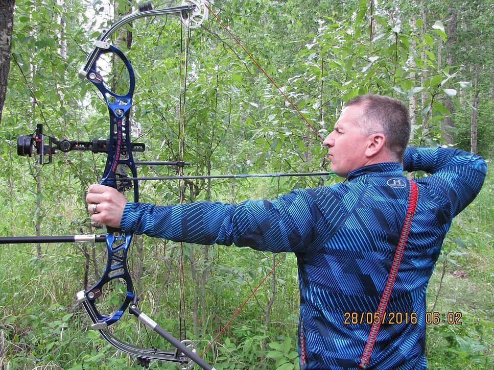Archery shooting an arrow at a field target.
