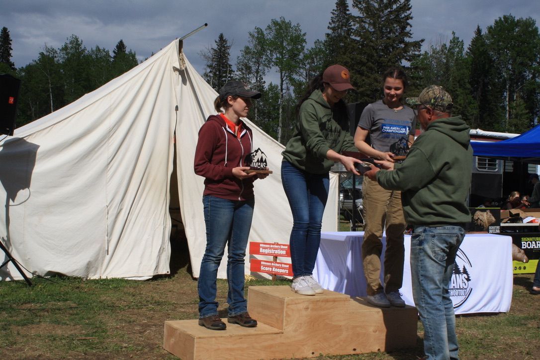 A group of people standing on a podium in front of a tent.