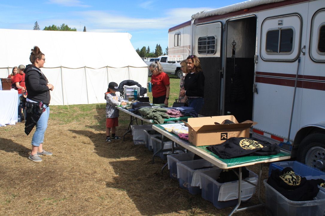 A group of people are standing around a table in front of a trailer.