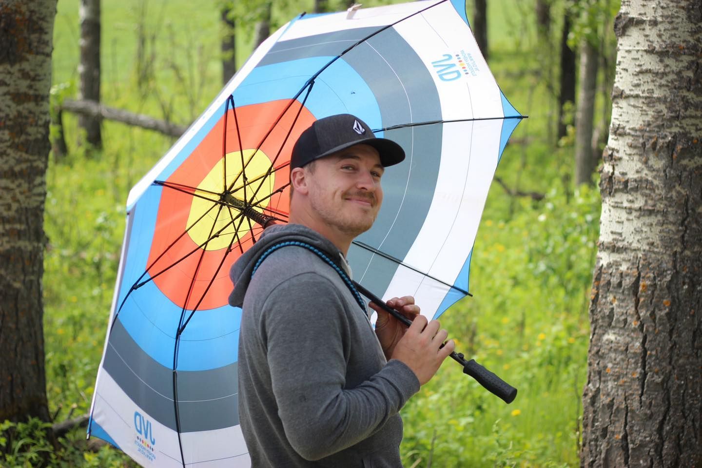 A man is holding an umbrella with a target on it