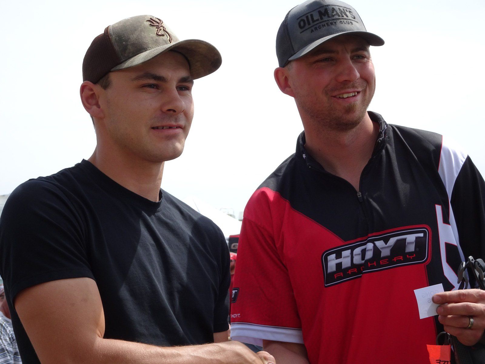 Two men shaking hands one wearing a hoyt shirt