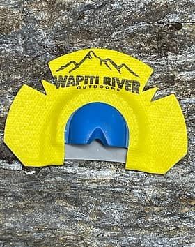 A yellow and blue object is sitting on top of a rock.