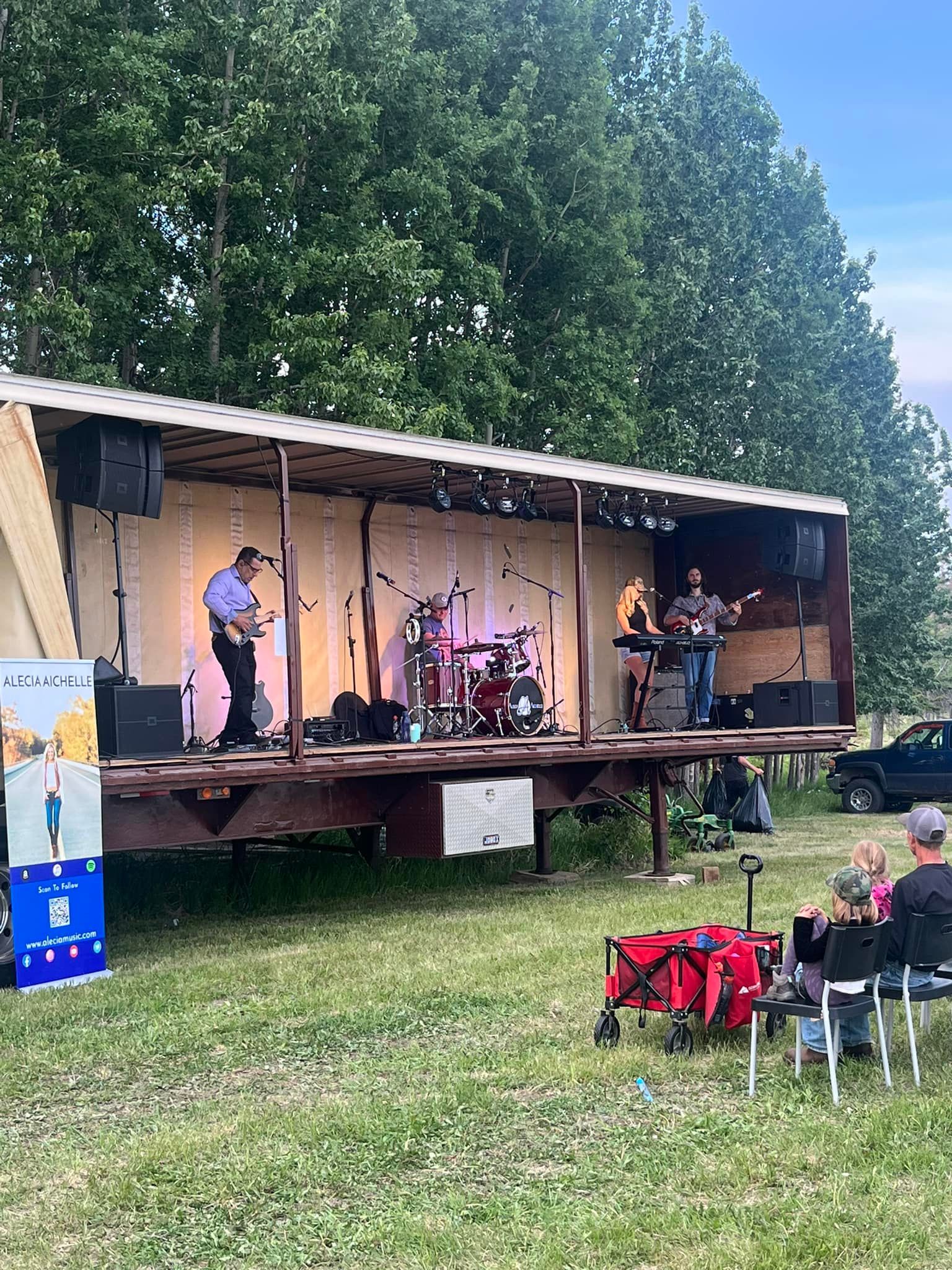 A group of people are sitting in chairs in front of a stage.