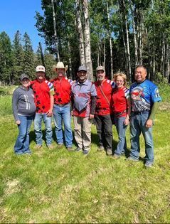 A group of people are posing for a picture in a field.